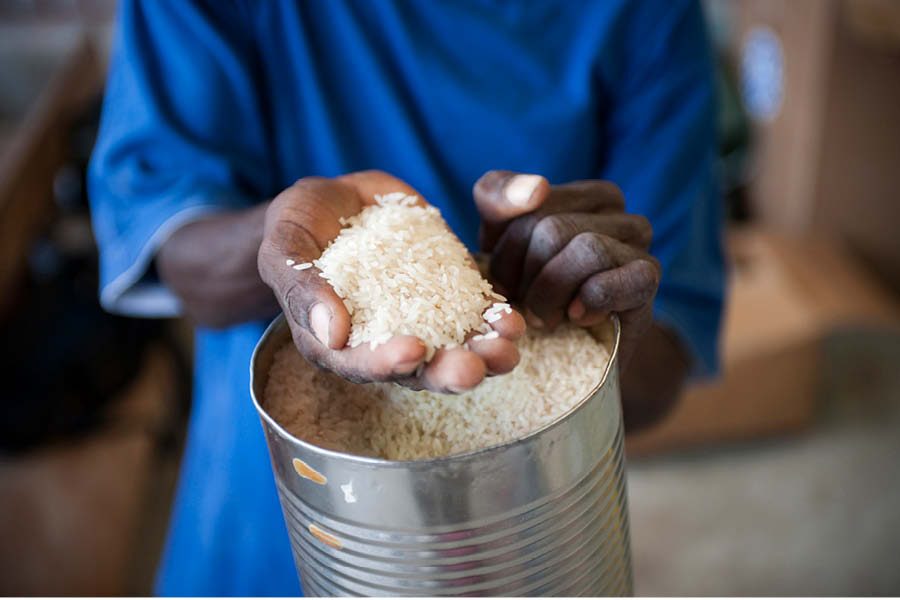 Haitian man holding uncooked rice